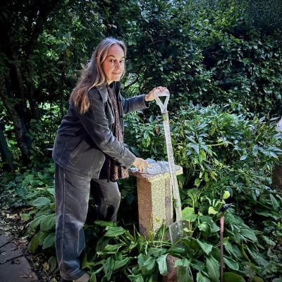 Spade med skörd, Sylvia Neiglick "Verket är en hyllning till alla trädgårdsmästare som verkat i malmgårdens odlingar genom tiderna. Spaden och sekatören blir trägårdsmästarens trogna arbetskamrater som alltid följer med och hjälper till i skapandet av en ny blomstrande rabatt eller en ny odlingsbädd. När man efter flera månaders slit får skörda frukten av arbetet ( tex en knippe kronärtskockor och ett knastrigt spetskålshuvud) kanske man lägger ifrån sig sekatören och det nyskördade på närmaste bänk, lutar spaden mot kanten och sätter sig ner en kort stund, kanske med en kopp kaffe för att snart återuppta det ständiga men givande arbetet. Den stunden vill jag porträttera med dessa objekt i glas och metall. Som om trädgårdsmästaren just lämnat dem där för en kort paus."