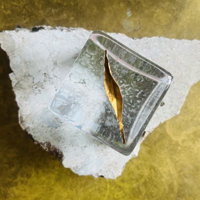 Jeanette Karsten ” Joy of life” , with golden leaf’ Fågeln kommer med den lilla kvisten som gåva som symbol för hopp, fred, lycka, glädje och vänskap. Symbol ovansida- Material: Gjutet glas, håndmåleri, gravyr, metall Podie: oregelbunden kalksten från Burgsvik på Gotland Mått: ca 20 cm x 10 cm. Höjd 2 cm. Teknik: Hyttformat glas med handgraverat m. färg.  Signerad Jeanette karsten unik