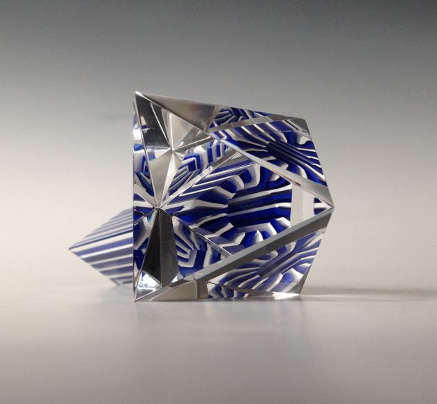 Material: Slipat och polerat prisma av murrini som limmats p&aring; en triangul&auml;r bipyramid polyeder  gjord av slipat och polerat optiskt glas. Optiskt glas &auml;r glas av h&ouml;g kvalitet med speciella ljusbrytande egenskaper f&ouml;r olika optiska  instrument som till exempel teleskop. M&aring;tt: 7 x 7 x 7 cm Design, utf&ouml;rande, foto: Anna Carlgren